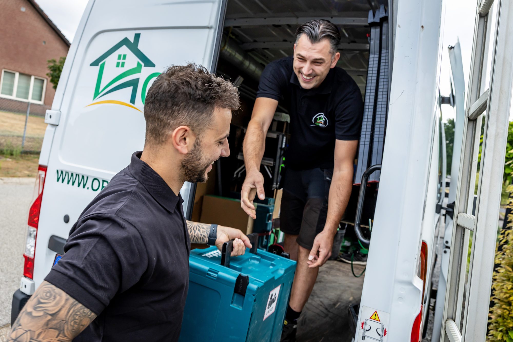 Opteco installateurs laden installatiemateriaal uit de bestelwagen